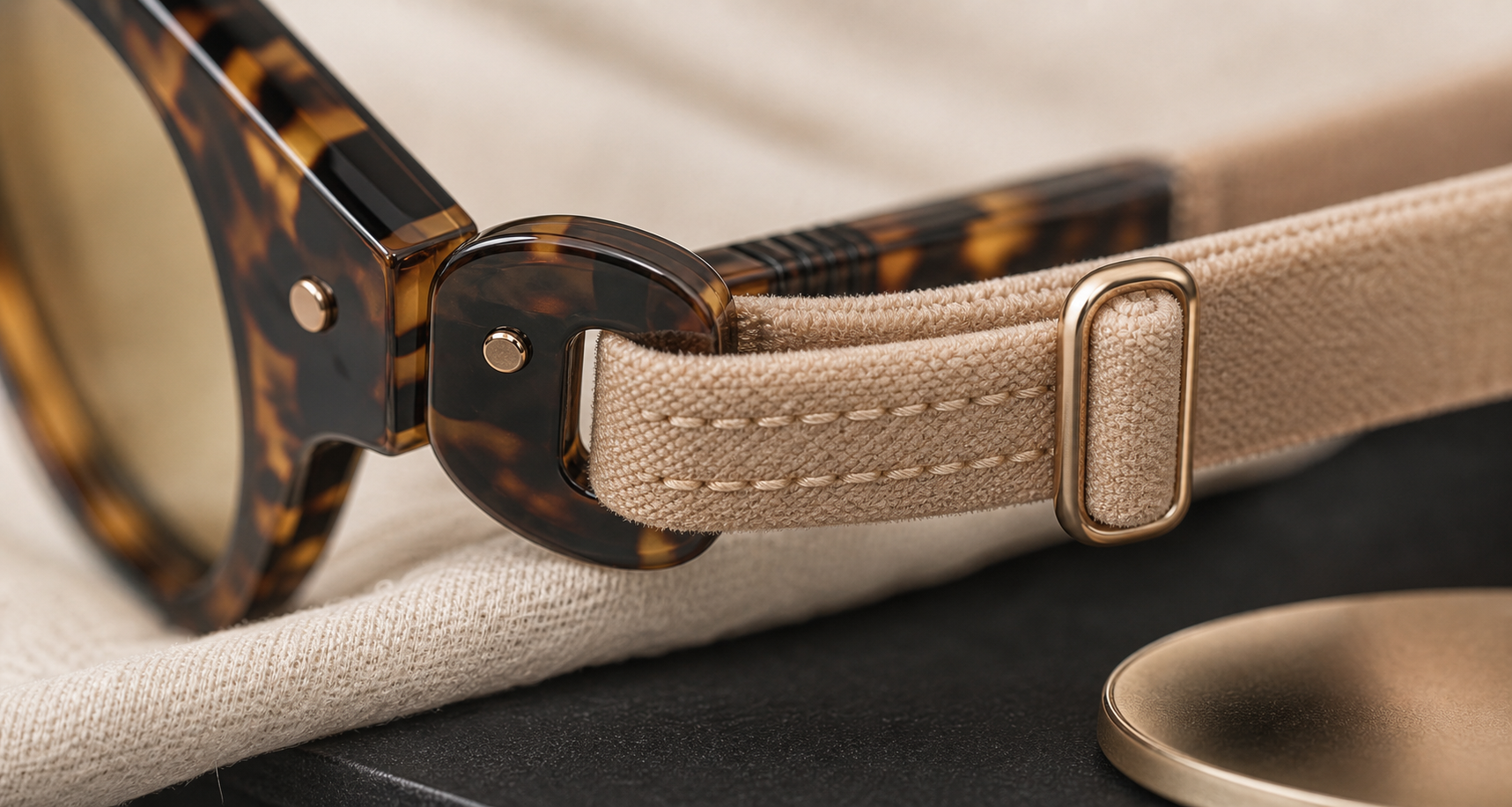 Close-up of Catelier eyewear strap stitching and rounded acrylic attachment point